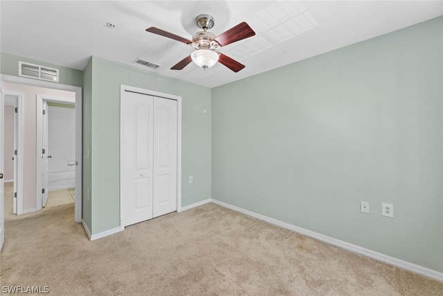 unfurnished bedroom featuring light carpet, ceiling fan, and a closet