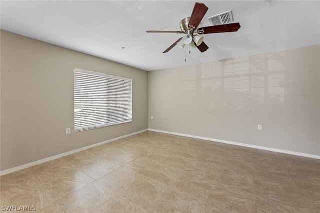 tiled spare room featuring ceiling fan