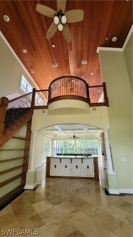 staircase featuring ornate columns, light tile patterned floors, and ceiling fan