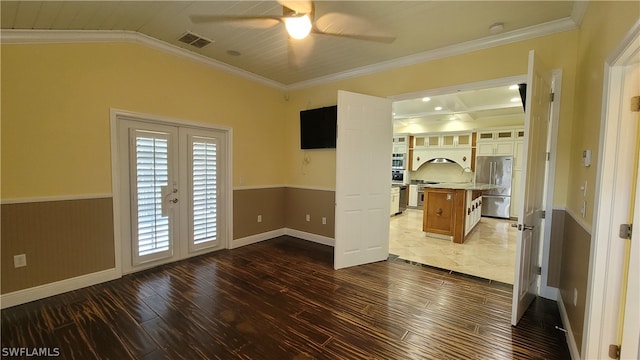 tiled empty room with lofted ceiling, french doors, crown molding, and ceiling fan