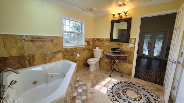 bathroom featuring tile patterned floors, tile walls, crown molding, french doors, and toilet