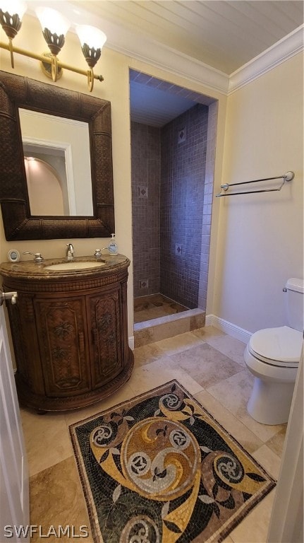 bathroom featuring vanity, ornamental molding, a tile shower, toilet, and tile patterned flooring