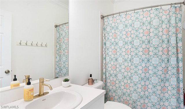 bathroom with vanity, crown molding, and toilet