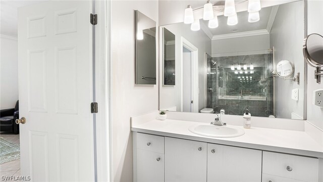 bathroom featuring a shower with shower door, vanity, crown molding, and tile patterned floors