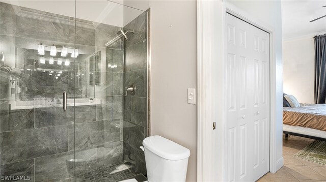 bathroom featuring tile patterned floors, an enclosed shower, and toilet