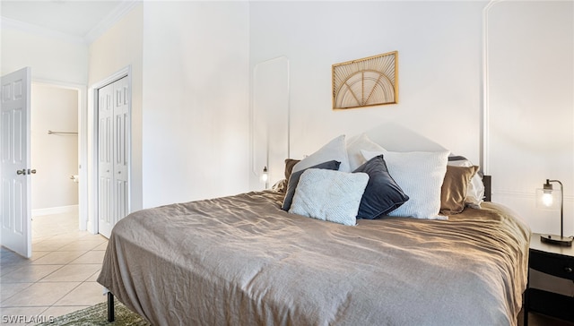 tiled bedroom with crown molding and a closet