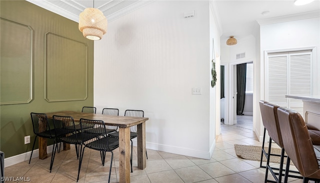 tiled dining room featuring crown molding