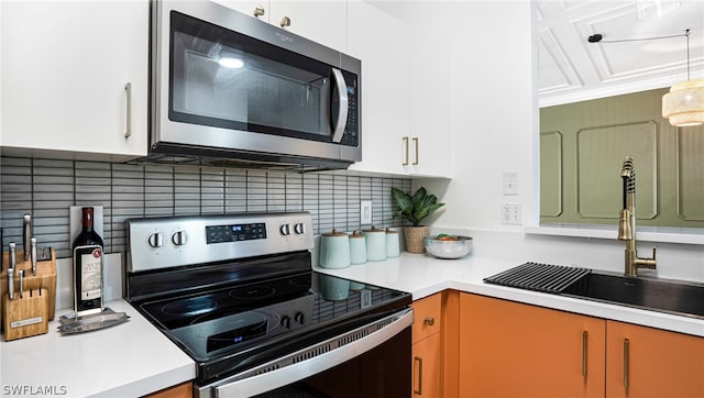 kitchen with white cabinetry, stainless steel appliances, tasteful backsplash, and sink