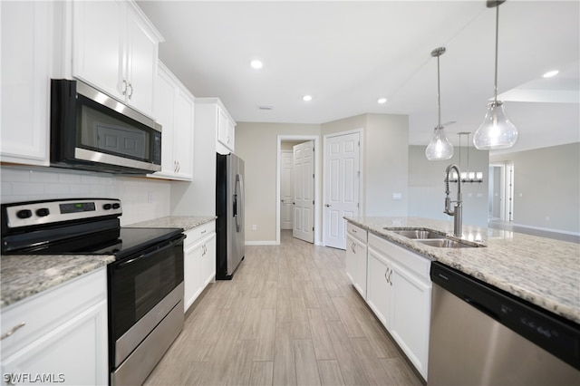 kitchen featuring pendant lighting, backsplash, sink, white cabinetry, and appliances with stainless steel finishes