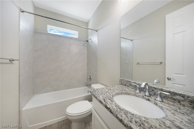 full bathroom featuring hardwood / wood-style flooring, tiled shower / bath, toilet, and vanity with extensive cabinet space