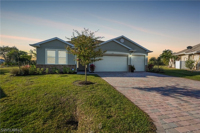 single story home with a garage and a yard