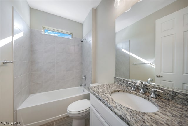 full bathroom with vanity, toilet, and tiled shower / bath combo