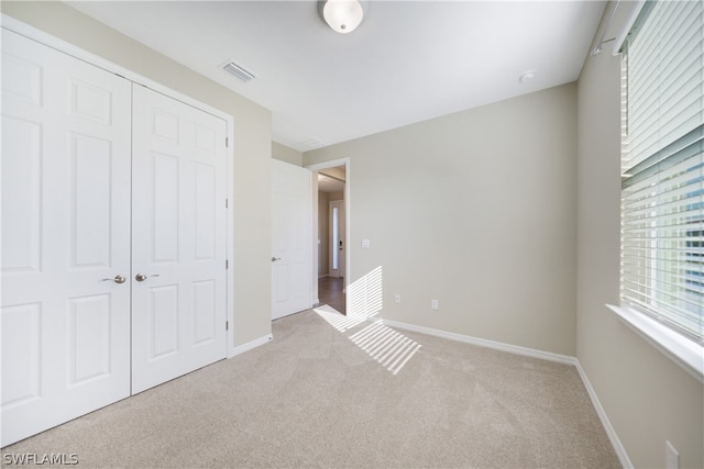 unfurnished bedroom with a closet and carpet flooring