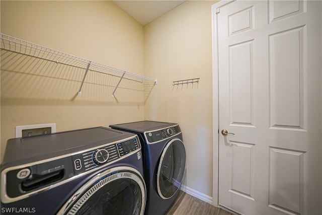 laundry room with wood-type flooring, washer hookup, and washing machine and clothes dryer