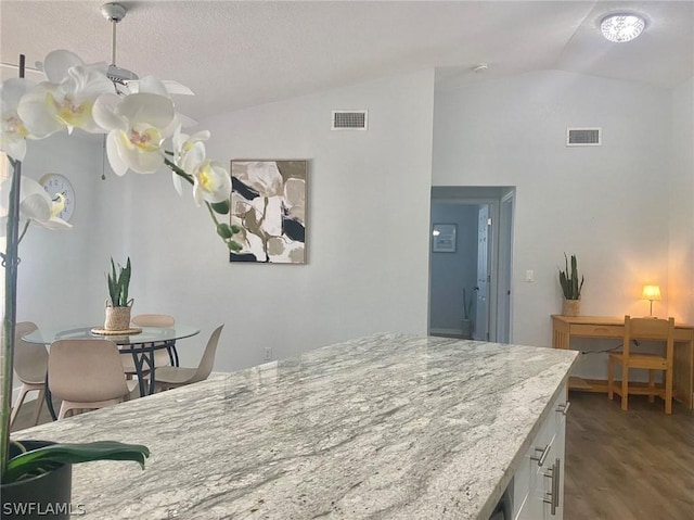 dining space featuring vaulted ceiling and wood-type flooring