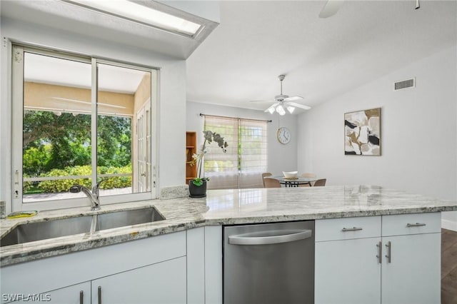 kitchen with vaulted ceiling, white cabinetry, dishwasher, and sink