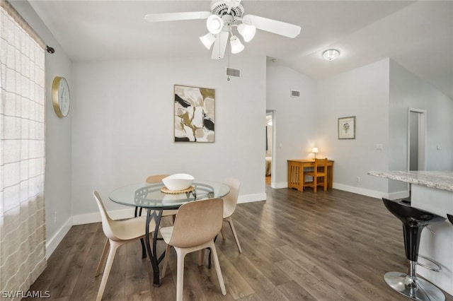 dining space with ceiling fan, dark hardwood / wood-style flooring, and vaulted ceiling