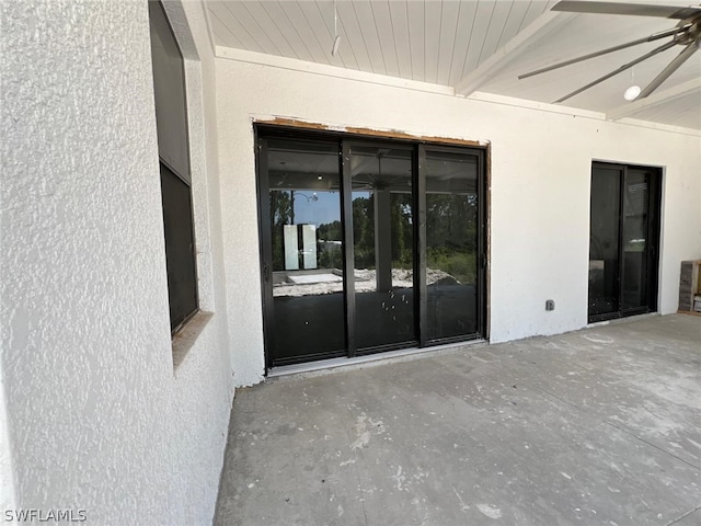 entrance to property featuring ceiling fan and a patio