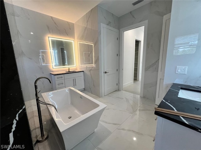 bathroom with vanity, a bathtub, and tile walls