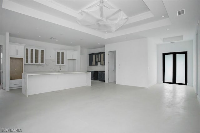 unfurnished living room with a tray ceiling