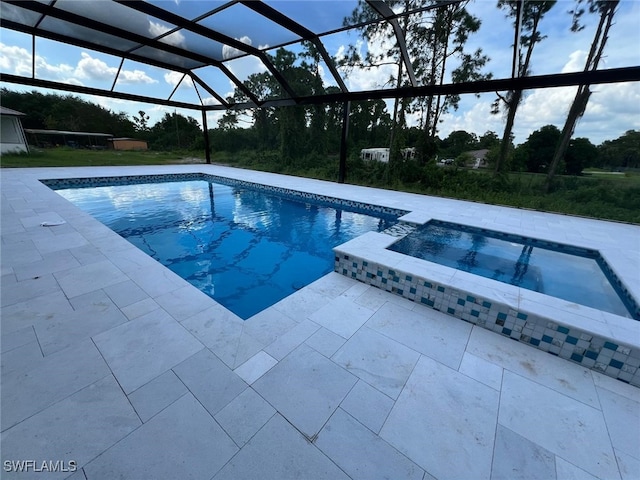 view of pool with a lanai, an in ground hot tub, and a patio