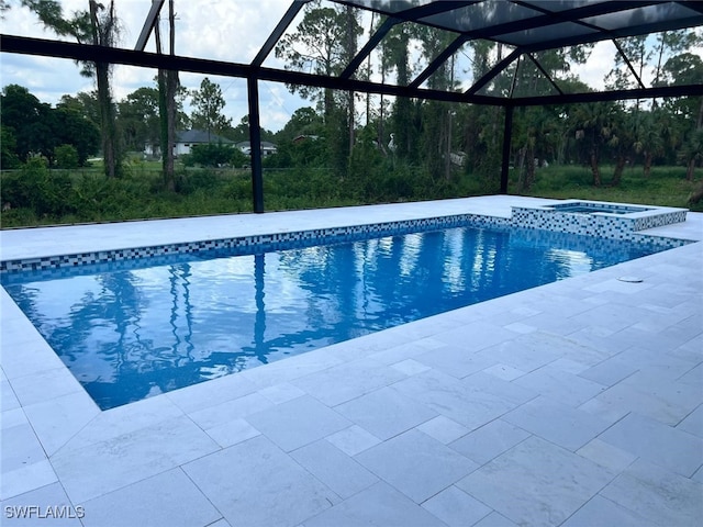 view of pool with glass enclosure and an in ground hot tub