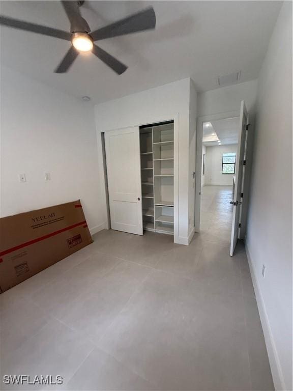 unfurnished bedroom with ceiling fan and a closet