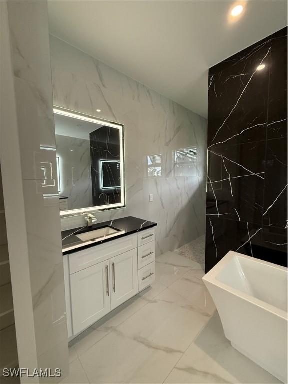 bathroom with vanity, separate shower and tub, and tile walls