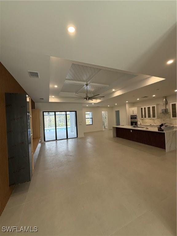 unfurnished living room with ceiling fan and sink