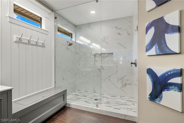 bathroom with a tile shower, hardwood / wood-style flooring, and vanity