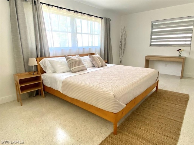 bedroom with speckled floor and baseboards