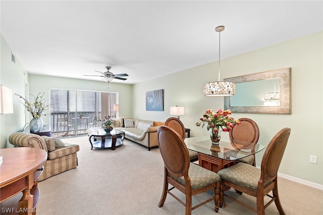 dining area with light carpet and ceiling fan