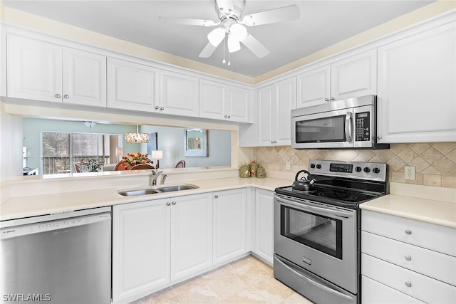 kitchen featuring white cabinets, decorative backsplash, sink, ceiling fan, and appliances with stainless steel finishes