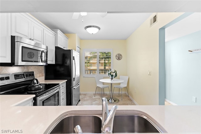 kitchen with white cabinetry, sink, appliances with stainless steel finishes, tasteful backsplash, and ceiling fan