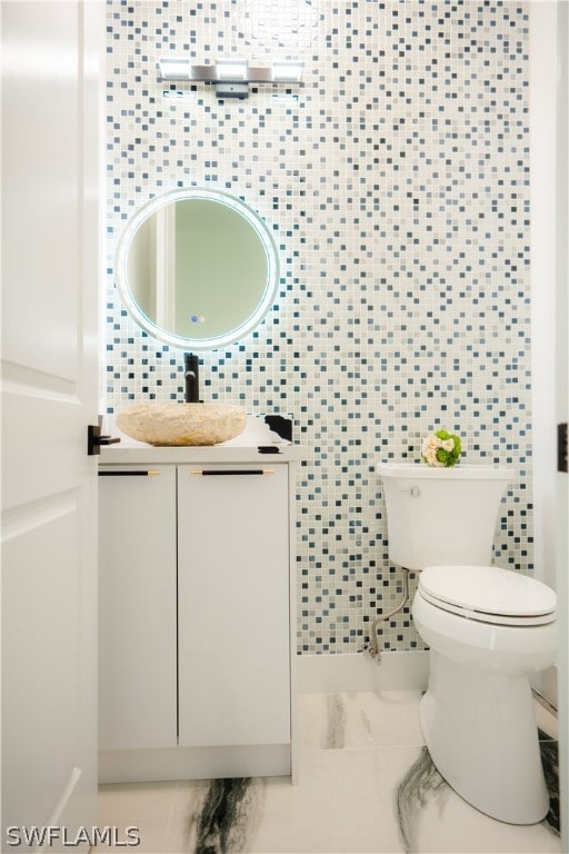 bathroom featuring decorative backsplash, vanity, tile walls, and toilet