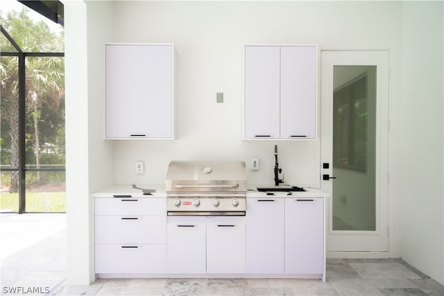 kitchen featuring white cabinets, a healthy amount of sunlight, and sink