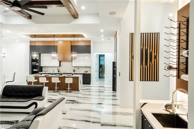 kitchen with pendant lighting, sink, ceiling fan, tasteful backsplash, and a kitchen island