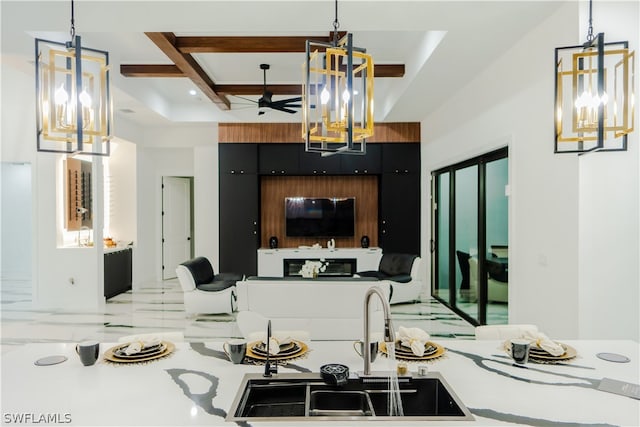 kitchen with sink, pendant lighting, and ceiling fan with notable chandelier