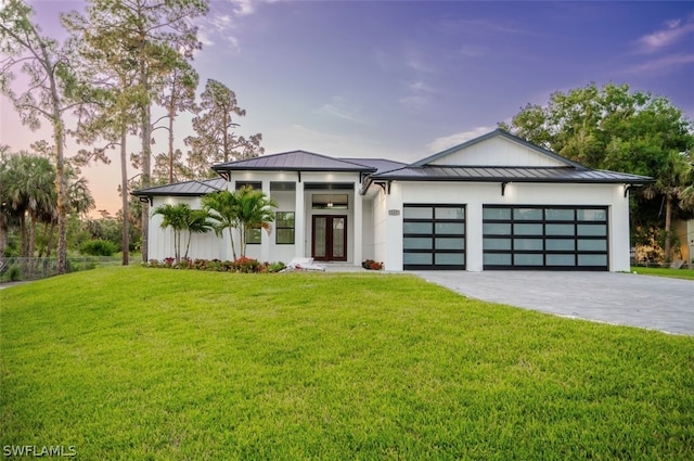 view of front of house featuring french doors, a yard, and a garage