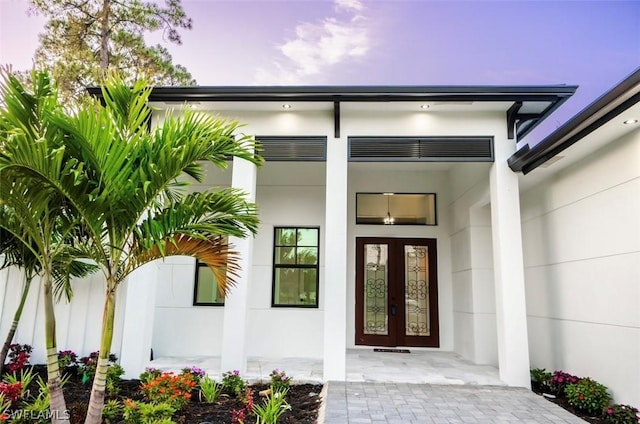 exterior entry at dusk featuring french doors