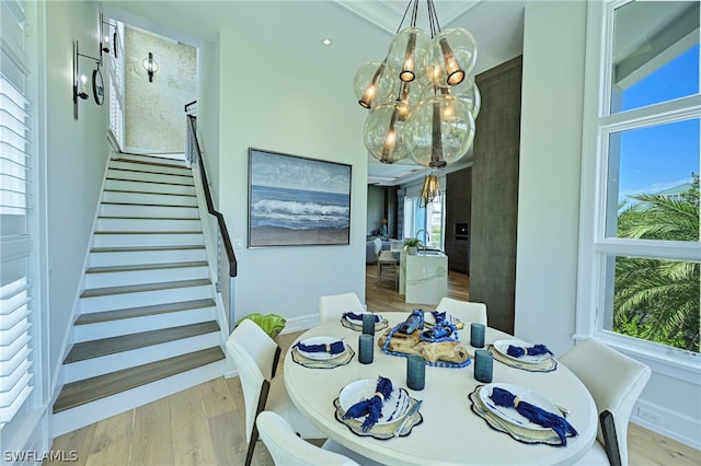 dining room featuring an inviting chandelier, hardwood / wood-style floors, and ornamental molding