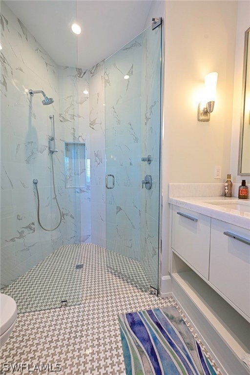 bathroom with tile floors, an enclosed shower, toilet, and vanity