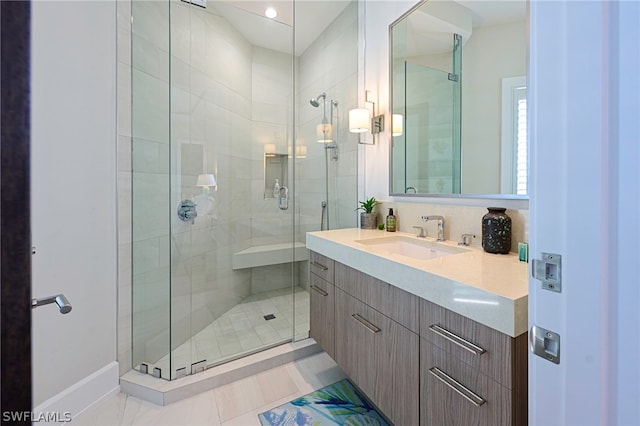 bathroom with tile flooring, a shower with shower door, and large vanity