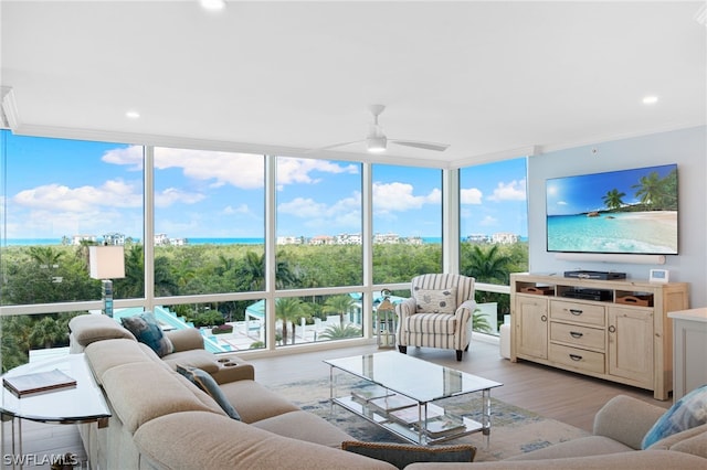 living room featuring light wood-type flooring, ceiling fan, and expansive windows