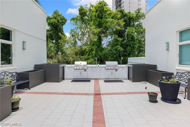 view of patio with exterior kitchen and a grill