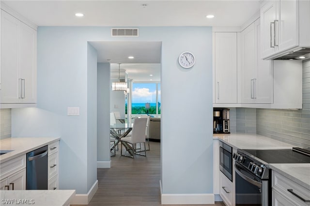 kitchen with dishwasher, built in microwave, range with electric stovetop, white cabinets, and light stone countertops