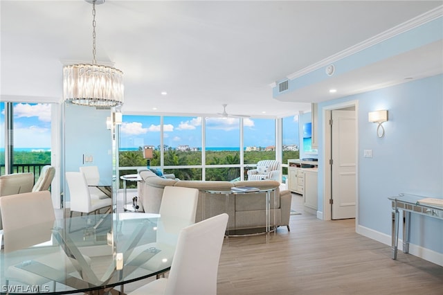 dining area featuring expansive windows, a notable chandelier, light hardwood / wood-style floors, and a wealth of natural light