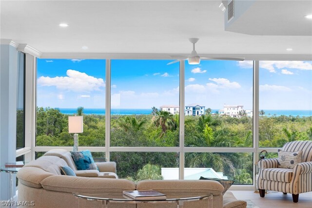 sunroom with a water view, a wealth of natural light, and ceiling fan