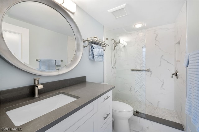 bathroom featuring toilet, vanity, and a tile shower