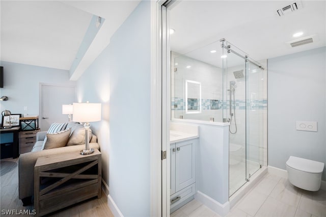 bathroom featuring vanity, toilet, and a shower with shower door